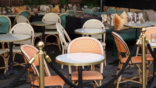 Sidewalk cafe  with small round tables and empty chairs - coffeehouse, coffee shop, diner or restaurant.