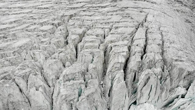 Aerial view of the Moiry glacier near Grimentz in Valais, Switzerland with a panning up view of the icy crevasses towards the clouds hiding the mountain peaks