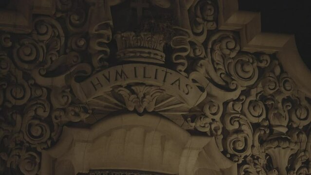 Handheld close up shot of the word HVMILITAS in a wall