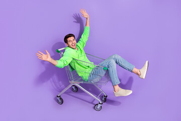 Full length photo of funny excited guy dressed neon sweatshirt shopping tray rider isolated violet color background