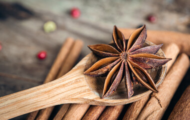 Star anise and cinnamon sticks close-up on a wooden background.
