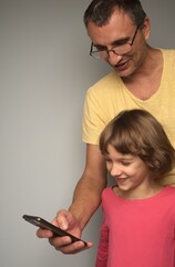 father showing his daughter something funny on the phone
