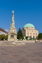 view of the Holy Trinity Statue and the Pasha Qasim Mosque on the Szechenyi Square in downtown Pécs