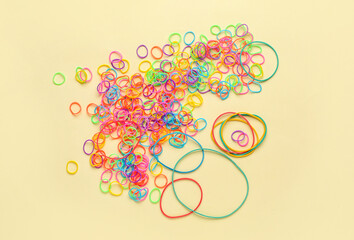 Heap of office colorful rubber bands on color background