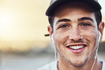 Earphones, smile and face portrait of a man in the city listening to music with a positive mindset. Happy, young and handsome guy streaming audio, radio or podcast in an urban town with mockup space.
