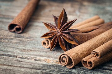 Star anise and cinnamon sticks close-up on a wooden background.