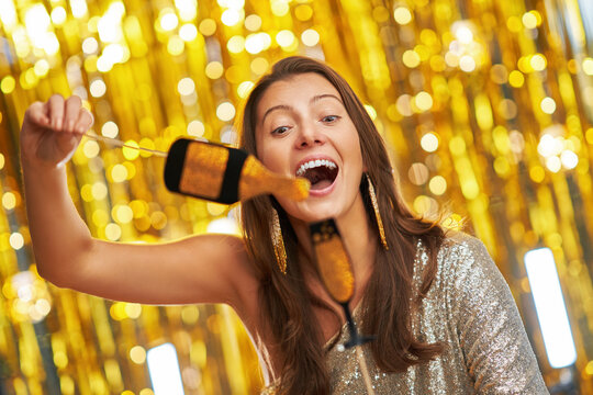 Young woman over gold background with photo booth accessories