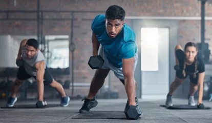 Men, woman and dumbbells in gym workout, training and exercise for strong body muscles, health and wellness. Portrait, sweat or fitness weightlifting class for people or friends with personal trainer © Irshaad M/peopleimages.com