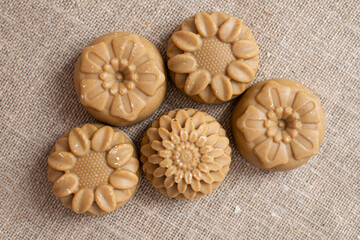 A small handmade soap is laid out in even rows against the background of the canvas. Lots of turmeric soap.