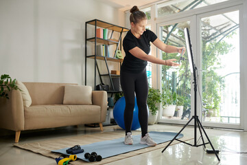 Fototapeta na wymiar Online Fitness Instructor Setting Equipment