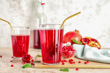 Glasses with fresh pomegranate juice on table