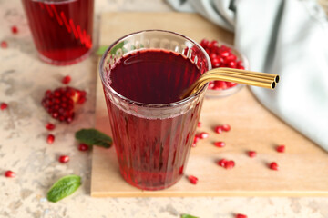 Glass of delicious pomegranate juice on color table, closeup