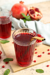 Glasses of delicious pomegranate juice on color background, closeup