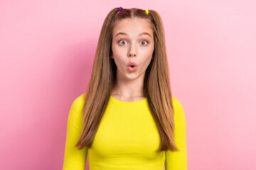 Photo of positive optimistic schoolgirl with ponytails dressed yellow long sleeve impressed staring...