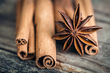 Star anise and cinnamon sticks close-up on a wooden background.