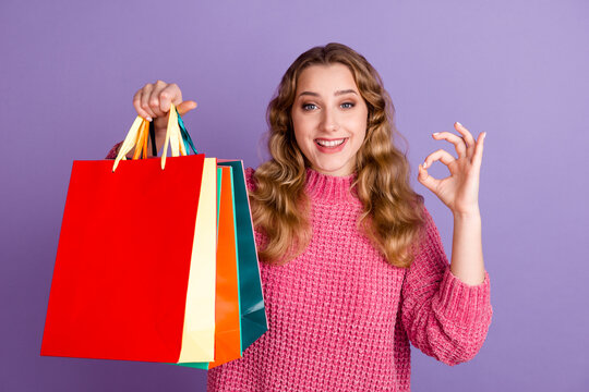Photo of happy shopper woman hold bags sale buy make okay symbol isolated on purple color background