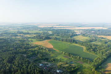 Fototapeta na wymiar The countryside from the height is a green ecological area. Summer panorama of the countryside among the green trees - aerial drone shot.