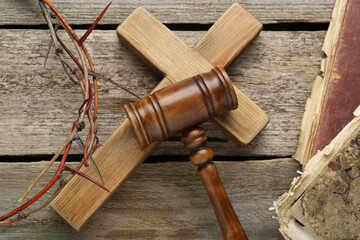 Judge gavel, cross and crown of thorns on wooden table, flat lay