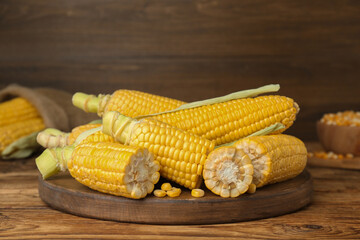 Fresh corncobs on wooden table. Space for text