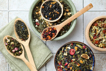 Many different herbal teas on white tiled surface, flat lay