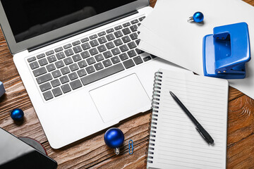 Office stationery with laptop and Christmas balls on wooden background