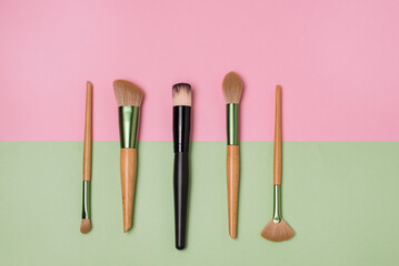 Set of Decorative Cosmetics on Green and Pink Background Makeup Synthetic Brushes Beauty Products Top view Flat lay Concept
