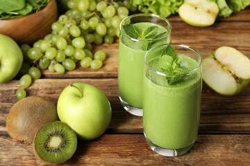 Green smoothie in glasses and fresh ingredients on wooden table