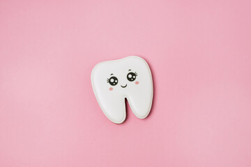 Gingerbread in the Shape of a Tooth Background for the Concept of Pediatric Dentistry and Tooth Fairy Pink Background