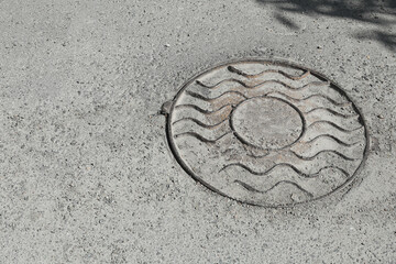 Fototapeta na wymiar Metal sewer hatch on asphalt outdoors, space for text