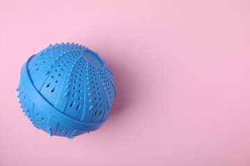 Laundry dryer ball on pink background, top view. Space for text