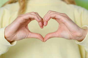 Young woman making heart with hands, closeup