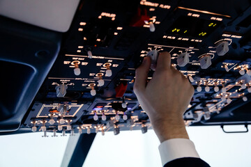 Pilot hand is controlling plane toggle switches to fly take off and landing