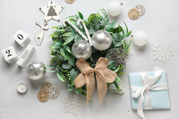 Composition with stylish Christmas wreath, gift and decorations on white background