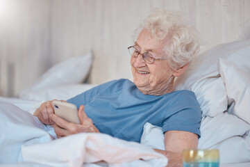Phone, bed and social media with a senior woman typing a text message while in the bedroom to relax. Contact, communication and mobile with a mature female reading or texting alone in the house