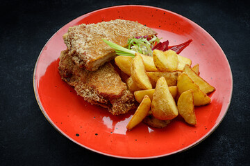 Pork schnitzel with potatoes, sauce and herbs