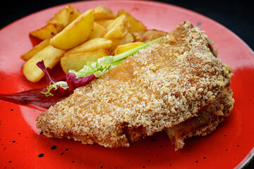 Pork schnitzel with potatoes, sauce and herbs