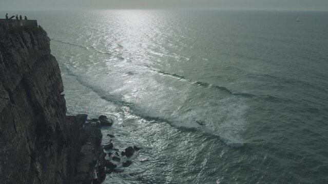 Ocean coast at sunset in Azenhas do Mar, Portugal, Colares area, near Sintra. Azenhas do Mar is a popular tourist destination in Portugal. Beautiful white houses with red roofs are visible.