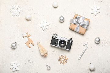 Photo camera with Christmas decor and gift on white background
