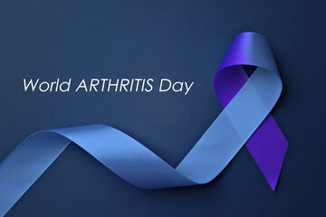 World Arthritis Day. Blue and purple awareness ribbon on color background, top view