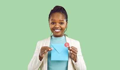 Portrait of smiling young African American woman hold paper envelope with unread notification....