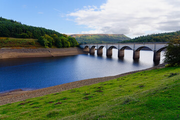 Fototapeta na wymiar An arched road bridge crosses the River Derwent at Ladybower reservoir.