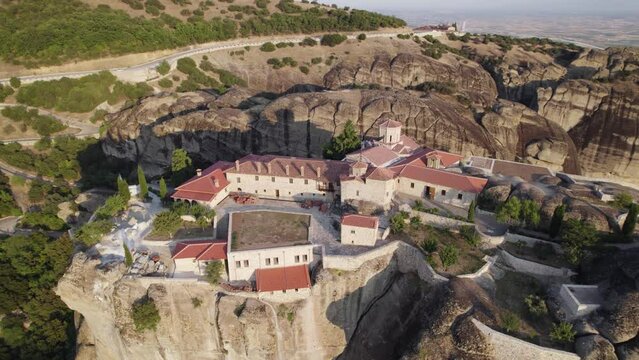 Aerial circling view of Monastery of the Holy Trinity on top of the cliff, Meteora, Greece