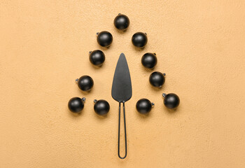 Christmas tree made of cake spatula and balls on beige background