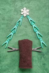 Christmas tree made of clothespins, towel and snowflake on green background