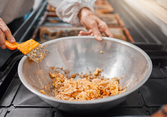Hands, honeycomb and bowl for organic food processing, preparation or extract at the workplace. Hand of beekeeper working in honey making, extraction or agriculture for food, retail or producing