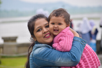 Mother and daughter or cute baby girl posing in Garden. 