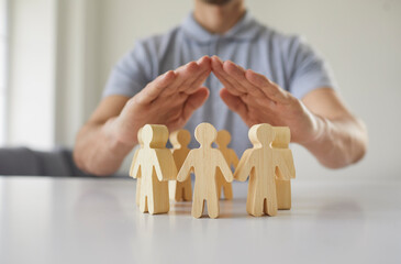 Close up employer holding hands over little pawn people. Responsible corporate business manager...