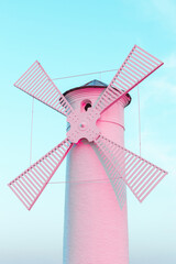 Trending color coral pink surreal lighthouse windmill on a blue sky pastel background - 548209039