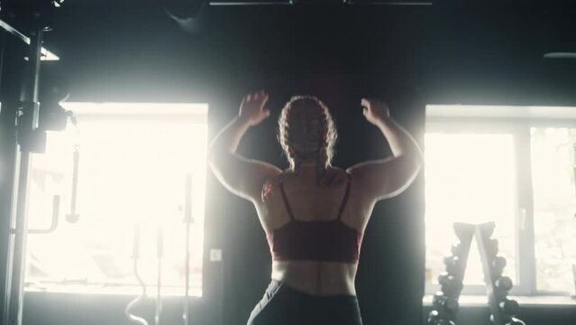 Camera Following a Woman With Athletic Body Going to do Pullups Training and Exercises in a Hardcore Gym. A Future Female Champion Working out on Her Endurance with Gym Equipment. Slow Motion