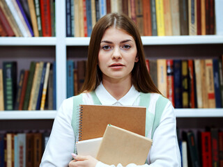 Portrait of student against bookcase in library